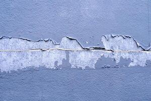 Weathered Blue Wall with Peeling Paint and Textured Surface Capturing Urban Decay and Artistic Abstract Patterns in a Close-Up View photo