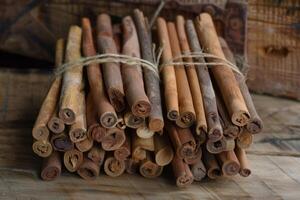 Cinnamon sticks tied together with string lying on rustic wooden surface photo