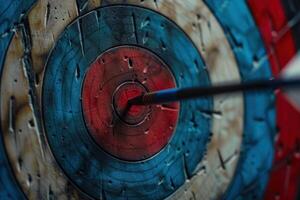 Blue arrow hitting the center of colorful target on wooden background photo