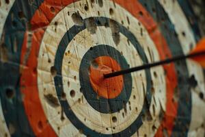 Arrow hitting the center of an old target on a target range photo
