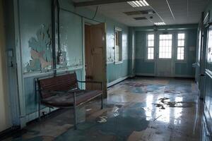 Empty bench in hallway of abandoned mental hospital building photo