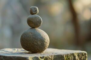 Stack of rounded zen stones balancing on rock in nature setting photo