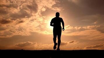 Silhouette of a Man Running at Sunset with Dramatic Sky and Clouds in the Background photo