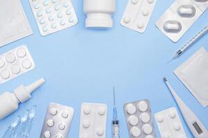 Medical supplies and pharmaceutical products arranged on a blue background. Copy space. Stock photo