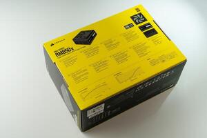 December 2023, Tallinn, Estonia. Corsair Power Supply. The box is a matte black color with yellow text and a picture of a computer part on the front. The part is a power supply unit. The box is isolated on a white background. photo