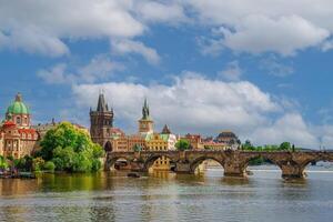 Beautiful cityscape image of Charles Bridge and Prague Castle with blue sky and white clouds in background, Czech Republic, Europe. Famous travel destination and touristic attraction of Czech Republic. photo