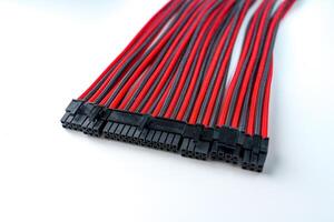 A black and red computer cable is isolated on a white background, designed for connecting various electronic devices with flexible material and different connector types. photo