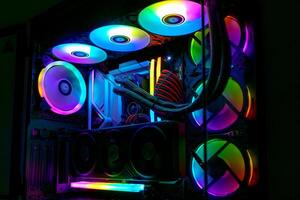 This captivating stock image features a modern desktop computer with vibrant RGB lighting. The transparent side panel showcases colorful components and glowing fans, enhancing its futuristic look. photo