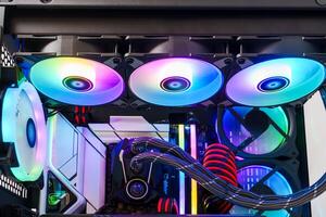 This image showcases a sleek black computer case for gamers. It features three RGB cooling fans at the front and a tempered glass side panel, blending aesthetics with functionality for an impressive look. photo
