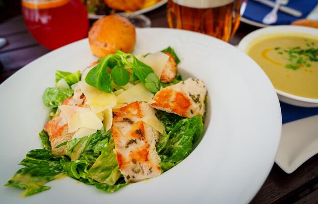 A delicious caesar salad with grilled chicken, fresh romaine lettuce, and creamy dressing. Topped with shaved parmesan, it offers a satisfying and flavorful meal for any occasion.