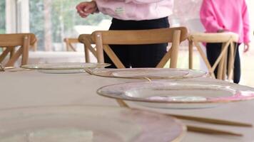 Event planner sets a table with golden cutlery, showcasing elegance and luxury in a slow-motion preparation scene video