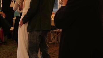 Groom holding his bride's waist while dancing slowly at their wedding reception, creating a romantic and intimate moment video