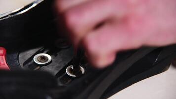 close up view of worker screwing binding to snowboard in repair shop. hands working with screwdriver. rental center video