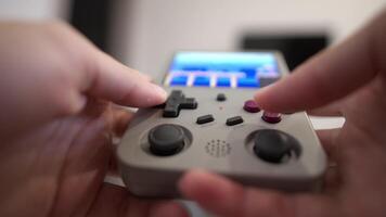 Close-up of female hands of young Caucasian woman holding retro game console. Girl playing retro games on portable game console. Shallow depth of field. Selective focus video