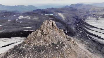 4K, shooting national park in snow in summer and peaks with cloudy sky. rocky mountains and mountain range, desert terrain, smooth drone flight video