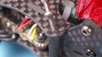 Macro close-up. A removed Allen screw in the carbon frame of a self-assembled quadcopter. The top plate and power wires are in the frame. selective focus video