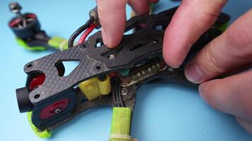 Disassembling a self-assembled FPV drone for repair. Quadcopter under repair. Removing the upper carbon frame cover. video
