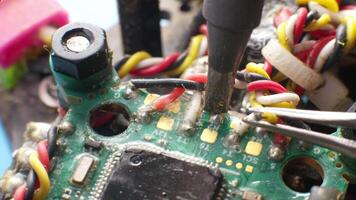 Extreme Close-up macro shot of a wire being prepared for soldering on a drone control board. Repairing the wiring harness of a used drone flight controller video