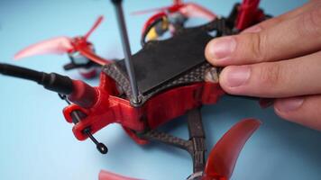 Close up of a hand screwdriver male craftsman unscrewing a fpv self-assembled drone on his desk. Shallow depth of field. Unscrewing and screwing video