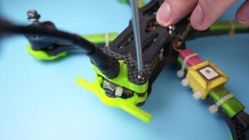 Close up of a hand screwdriver male craftsman unscrewing a fpv self-assembled drone on his desk. Shallow depth of field. Unscrewing and screwing video
