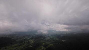 4K aerial view of mountains and green hills, beautiful clouds in the mountains at high altitude. Nebula descends to the ground, drone flight in the clouds video