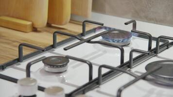 Close up of woman hand turning on gas on stove in kitchen. Woman lighting gas burner. Concept of having gas in house video