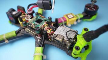 Disassembling a self-assembled FPV drone for repair. Quadcopter under repair. Removing the upper carbon frame cover. Diagnostics of wires for breakage video