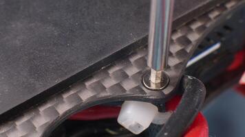 Macro close-up. A removed Allen screw in the carbon frame of a self-assembled quadcopter. The top plate and power wires are in the frame. selective focus video