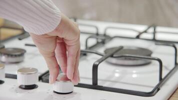 Close up of woman hand turning on gas on stove in kitchen. Woman lighting gas burner. Concept of having gas in house video