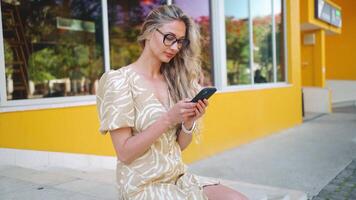 Blonde Woman Smiling using Smartphone video
