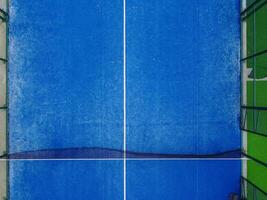 partial overhead view of the net and half of a paddle tennis court photo
