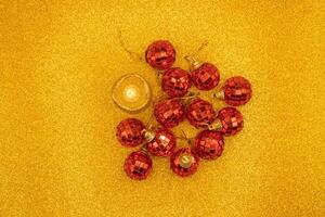 Several red Christmas balls on a shiny gold background. Top view. photo
