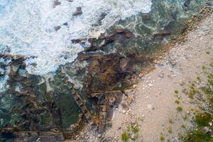 zenithal view of waves on a rocky shore photo