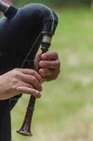 A person playing a bagpipe in the grass photo