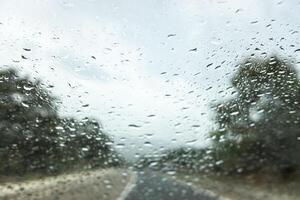 selective focus of raindrops on the windshield of a car in an autumn storm photo