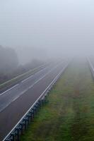 A car drives through fog on a freeway with little traffic. Highway with no traffic on a foggy day. Galicia. Spain photo