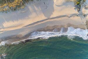 shore of a beach at sunrise, zenithal view with drone photo