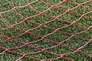 red netting of a football goal of an artificial grass football field photo