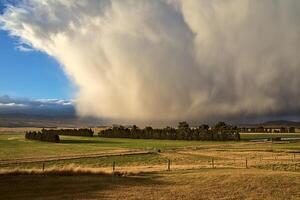 A large storm clouds over a field photo