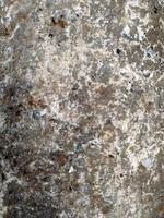 Textured surface of aged stone with unique patterns and natural hues found in an outdoor environment capturing the essence of time photo