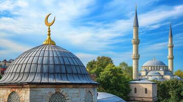 Beautiful mosque with domes and minarets surrounded by greenery under a bright blue sky with soft clouds photo