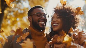 Happy couple smiling and embracing amidst golden autumn leaves, enjoying a joyful and romantic moment outdoors photo