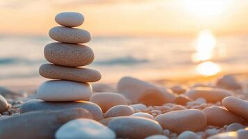Smooth stones balanced on a beach during sunset with soft light and a calm ocean view creating a serene atmosphere photo