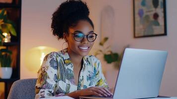 Focused young woman wearing glasses and working on a laptop in a cozy home office at night, surrounded by soft lighting photo