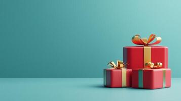 Red gift boxes with golden bows with copy space for text on a teal background representing festive Christmas holiday decor photo