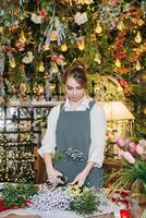 A woman in her florist shop collects bouquets of flowers. The concept of a small business. Bouquets of tulips for the holiday on March 8. photo