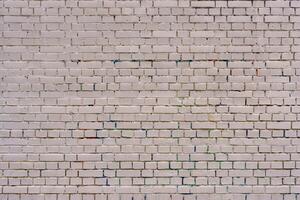 An old brick wall is painted with white paint. Abstract construction background. photo