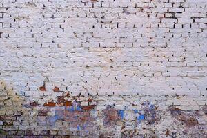 An old brick wall is painted with white paint. Abstract construction background. photo