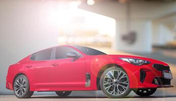 A red car on a background of city environment. Stylish, modern, bright image of the car for design solutions. photo