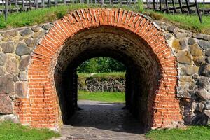 Stone arch and tunnel in the fortress wall. Vintage building background. photo